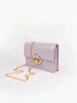 Cartera bandolera rectangular de cuero sintético color lila con textura tipo piel de avestruz. Tiene cierre metálico dorado con botón a presión y cadena dorada.