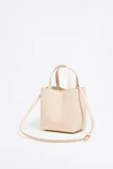 Bolso tote pequeño de cuero sintético color negro con doble asa de mano y correa bandolera ajustable y extraíble. Logotipo de la marca en letras doradas en la parte frontal.