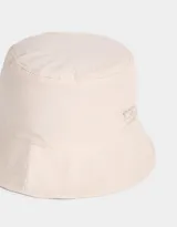 Piluso color beige de tela deportiva, reversible, con etiqueta de goma con logo de la marca.