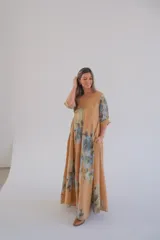 Vestido largo color camel con estampado de flores azules, corte amplio, escote en V y mangas 3/4.