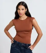 Body sin mangas color marrón óxido, con escote redondo y fruncidos laterales que generan drapeado en el torso.