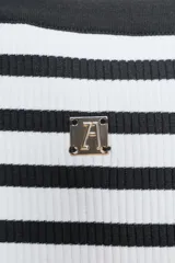 Top ajustado de rib a rayas horizontales blancas y negras, con escote recto y tirantes anchos. Tiene detalle de broche metálico en el frente y logo de Zara en la espalda.