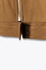 Cazadora color marrón de cuello solapa y manga larga acabada en puño con botón. Bolsillos de vivo en delantero, detalle de costuras marcadas, forro interior combinado a contraste y cierre frontal con cremallera y gancho metálico oculto.