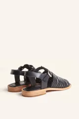 Sandalia de cuero color marrón con diseño de tiras entretejidas y hebilla lateral.