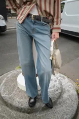 Pantalón de jean celeste de corte recto, tiro medio y cinco bolsillos. Incluye cinturón negro con hebilla plateada.