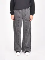 Pantalón de jean negro lavado, de tiro alto y corte ancho (wide leg), con costuras marcadas en el frente de cada pierna y cintura elástica.