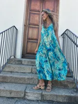 Vestido largo turquesa con estampado abstracto, corte al sesgo y escote en V tanto en la parte delantera como en la trasera.