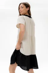 Vestido corto de algodón a rayas horizontales color beige, con cuello redondo negro y falda negra de lino.