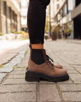 Borcego de gamuza color verde militar con elásticos laterales negros, cordones negros y suela de goma negra con plataforma.