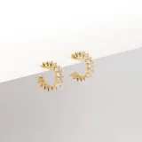 Aros en forma de argolla abiertos, dorados, con cristales de Cubic Zirconia incrustados.