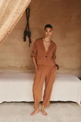 Pantalón color crema de tiro alto con pinzas delanteras y cintura elástica en la espalda. Tiene bolsillos delanteros y traseros.