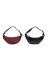 Cartera tipo hobo color bordó de cuero sintético, con cierre superior y asa regulable. Decorada con ojales metálicos plateados.