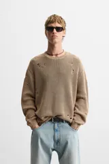 Sweater color marrón claro con efecto lavado ácido y roturas. De corte relajado, cuello redondo y mangas largas.