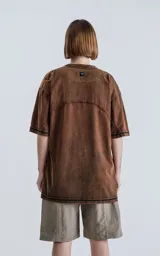 Remera marrón de cuello redondo y corte oversize, confeccionada en algodón con proceso de batik artesanal.