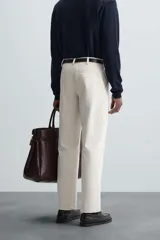 Pantalón chino de vestir negro, corte slim fit, con bolsillos laterales y traseros. Cierre frontal con cremallera y botón.