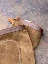 Polainas de cuero gamuzado color camel con detalle de tira de cuero marrón con logo de la marca grabado.