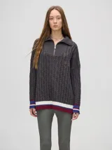 Sweater tejido de algodón color rosa claro, con cuello polo con cierre de cremallera metálica y mangas largas con puños a rayas de colores.