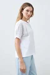 Remera roja de algodón con cuello redondo y mangas cortas con detalle de broderie. Corte clásico.