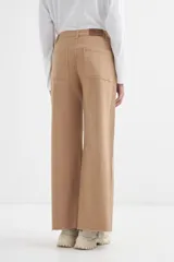 Pantalón jean color beige, de corte ancho y tiro alto.