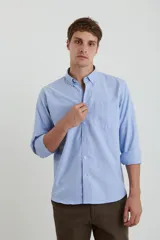 Camisa azul de corte regular, con cuello tipo polo y manga larga.