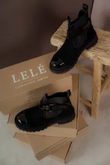 Botas de cuero color marrón oscuro, estilo Chelsea, con elástico lateral negro y suela track negra. Incluye correa de cuero desmontable con hebilla.