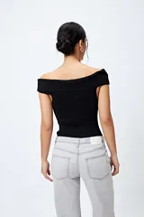 Top tejido color blanco con escote bardot que deja los hombros al descubierto y punto acanalado.