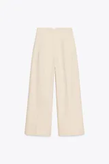 Pantalón color crema de lino, de tiro alto, corte recto y bolsillos delanteros.