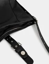Cartera hobo color marrón claro de cuerina con correa regulable y hebilla decorativa frontal.