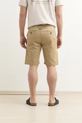 Bermuda de gabardina color verde con bolsillos laterales y traseros.