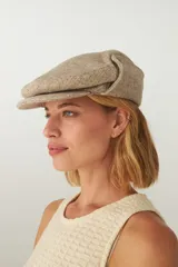 Boina con visera y orejeras de lana color beige con diseño de espiga.