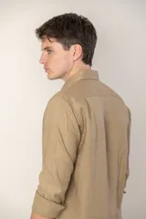 Camisa celeste de lino con cuello clásico y manga larga. Presenta un pequeño logo bordado en el pecho.