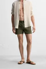 Short de baño negro de tejido técnico, con cintura elástica ajustable con cordón, bolsillos laterales y bolsillo trasero.