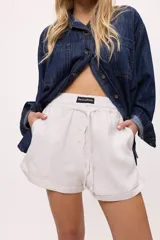 Short a rayas verticales color verde agua y blanco, con cintura elastizada y cordón ajustable.