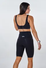 Conjunto deportivo negro compuesto por un top con logo y calza ciclista de tiro alto.