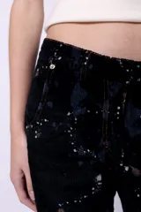 Pantalón de pana negro con estampado floral y tiro medio.