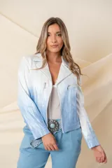 Chaqueta corta de cuero ecológico con diseño degradado de blanco a gris. Tiene cuello tipo solapa, cierre frontal asimétrico con broche y bolsillos con cierre.