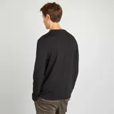 Camiseta negra de manga larga con cuello henley abotonado. Corte recto.