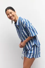 Short pijama con rayas verticales azules y blancas, con elástico en la cintura y cordones ajustables.