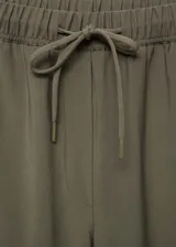 Pantalón fluido color verde militar, de corte recto, con cintura elástica ajustable con cordón y bolsillos laterales.