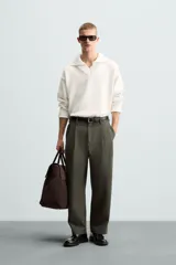 Sweater color crema de punto con cuello polo y escote en V.