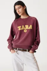 Sudadera lila de algodón con cuello redondo y mangas largas. Estampado en el frente con el logo "Zara A Coruña" y el texto "Est. 1975".