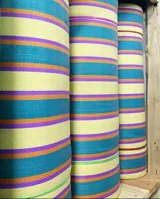 Bolso tipo tote grande con rayas verticales en celeste, blanco y bordó. Tiene doble asa corta en celeste con borde bordó, cierre superior y bolsillo interno.