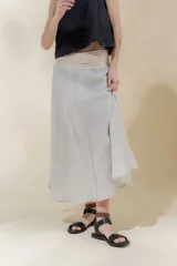 Falda midi de lino color gris claro, de silueta amplia y pretina elastizada color beige.