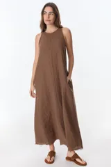 Vestido largo blanco de lino, sin mangas y con bolsillos laterales.