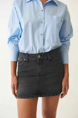 Minifalda clásica de denim, tiro a la cadera, con terminación recta y bolsillos funcionales.