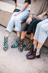 Botines de cuero con estampado de cebra en tonos verde claro y negro, con puntera fina y tacón cuadrado. Presentan paneles laterales elásticos en color verde liso.