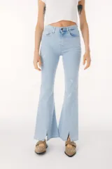 Pantalón de jean azul de corte acampanado con aberturas en el ruedo.