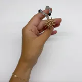 Collar elaborado con bolitas de piedra Fluorita en tonos verdes y morados, separadas por nuditos de hilo violeta. Cuenta con terminaciones y un dije grande en forma de sol con baño de oro.