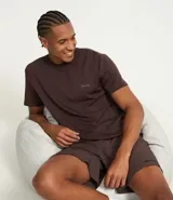 Remera deportiva marrón de corte clásico, cuello redondo y mangas cortas. Confeccionada en tejido de poliéster y modal con tecnología Dry, que facilita la transpiración. Presenta un pequeño estampado con lettering en el pecho.