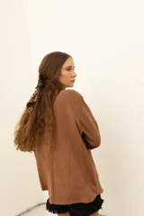 Camisa marrón de corte recto con cuello camisero, cierre frontal con botones, mangas largas con puños abotonados y bolsillos de parche en el pecho.